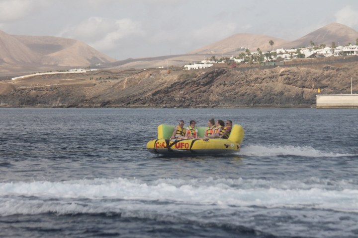 a small boat in a body of water with a mountain in the background