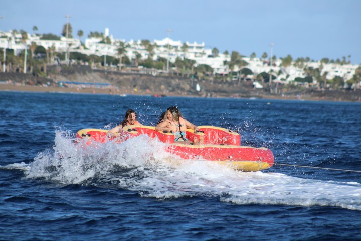 a man riding on the back of a boat in the water
