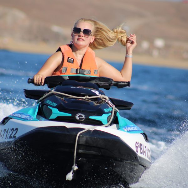 a person riding on the back of a boat in the water