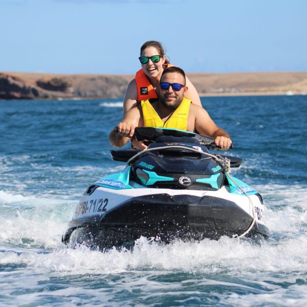 a man riding on the back of a boat in a body of water