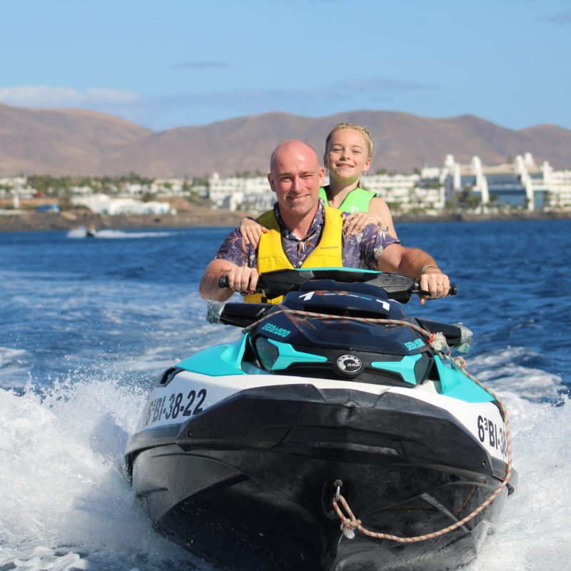 a man riding on the back of a boat in a body of water