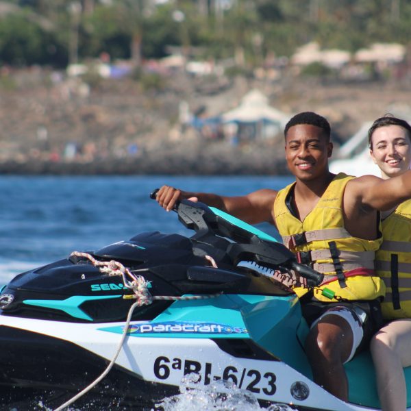 Aimee Steinberger riding on the back of a boat in the water